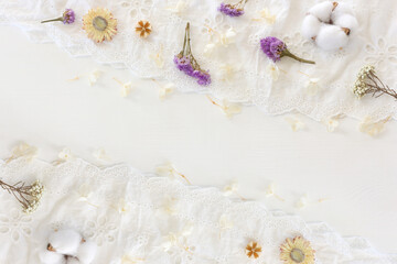 Background of white embroidered delicate lace fabric and dry flowers