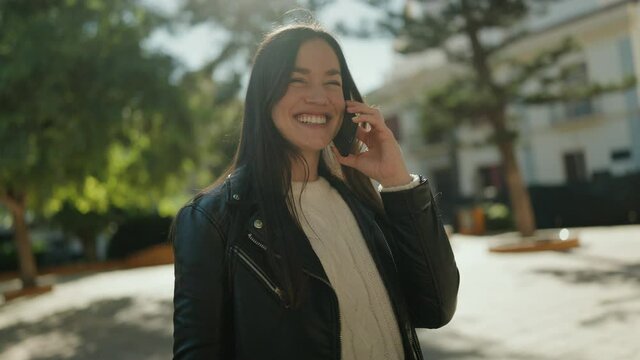 Young hispanic woman smiling confident talking on the smartphone at park