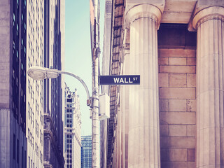 Color toned picture of Wall Street sign on a lamp post, selective focus, New York City, USA.