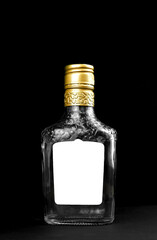 Mockup label on empty glass bottle of whiskey, cognac or vodka on a black background. Template,...