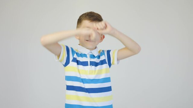 cute boy dancing fun in the studio on a white background. 4K images with cheerful little boy dancing happily