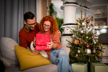 Obraz na płótnie Canvas Loving couple enjoying Christmas celebration at home by themselves.
