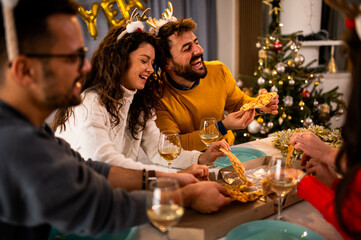 Loving couple enjoying Christmas celebration at home with friends 