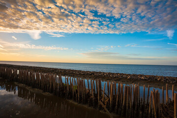 Sunset in a cloudy sky over open Baltic sea with veri distant ship silhouettes