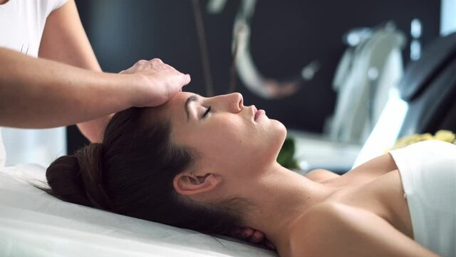 Video of beautiful young woman having reiki healing treatment in health spa center