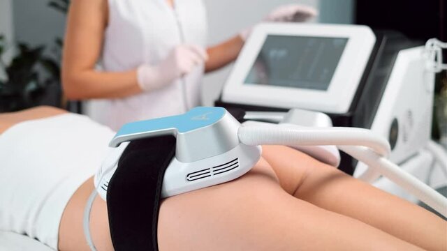 Video of close-up of woman lying receiving epilation laser treatment and anticellulite massage on buttock on the spa center.