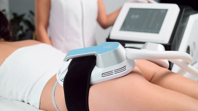 Video of close-up of woman lying receiving epilation laser treatment and anticellulite massage on buttock on the spa center.