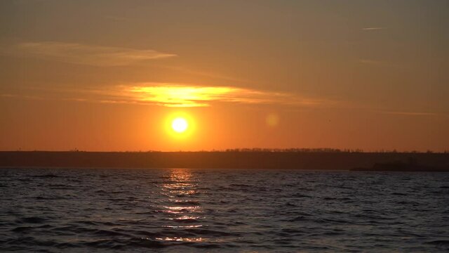 Waves and ripples on the water on the horizon a beautiful bright sunset. High quality FullHD footage