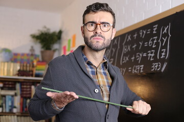 Severe school teacher holding stick
