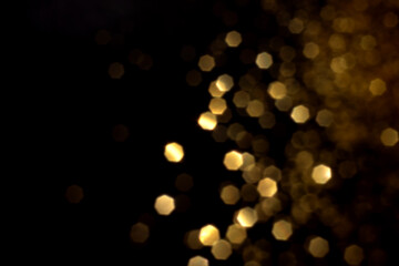 Golden blurred bokeh lights on black background. Glitter sparkle stars for celebrate. Overlay for...