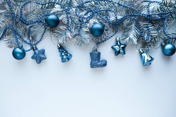 christmas background. frame made of fir branches and blue Christmas tree decorations. garlands and...
