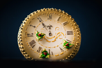Christmas gingerbread cookie in the shape of vintage clock with golden icing on the dark concrete background. Merry Christmas. New Year countdown