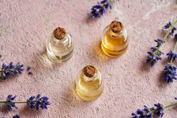 Bottles of essential oil with fresh blooming lavender