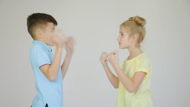 two children are arguing, the girl and the boy are arguing and gesturing with their hands, profile view.