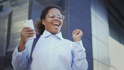 Happy successful black woman dancing victory dance, completing important deal