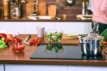Cooking process in kitchen - saucepan, vegetables on the table.