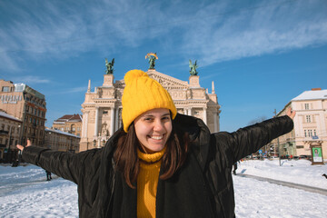 happy woman traveler in front of opera building in lviv city