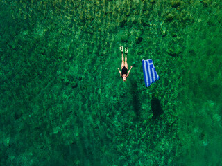 summer greece vacation woman floating in water with flag - obrazy, fototapety, plakaty