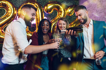 Happy group of friends celebrate New Year's Eve in a club