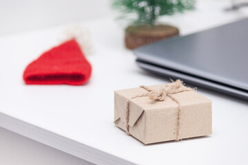 Santa hat, christmas tree, box, notebook on white table.