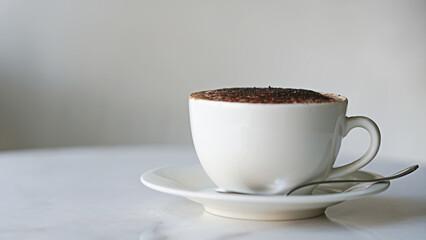 A white cup of cappuccino on the table                   