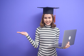 Portrait of young woman graduated over blue background