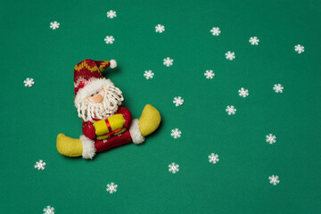 Santa claus with gift on green background with snow crystals