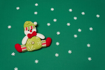 Snowman with red bow, on green background with snow crystals