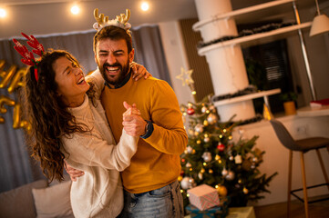 Fototapeta premium Couple in love having fun alone during New Year's Eve. Happy man and woman in their home during the holidays.