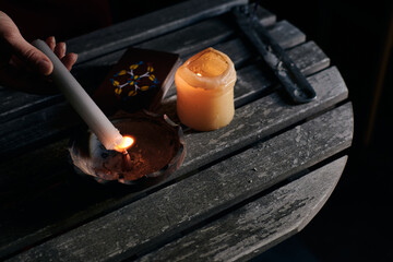 Lighting incense with a candle with tarot cards on the table