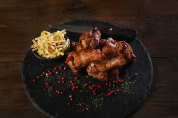 Delicious crispy chicken with dip and potato chips on dark background