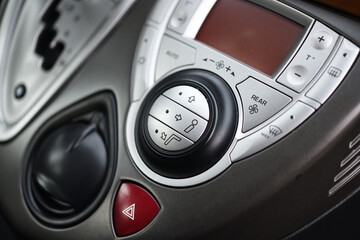 Fototapeta premium Car dashboard interior of modern car. Black cockpit with button and icon for air conditioner option, car window heating buttons and emergency lights button.
