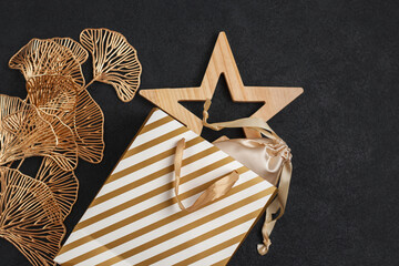 Gifts for the New Year or Christmas in gold colors on a black textured background. Festive mood and preparation for the holidays.