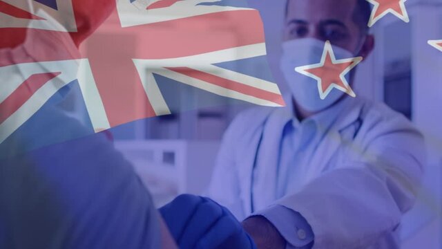 Animation of flag of australia over male doctor in face mask giving covid vaccination to patient