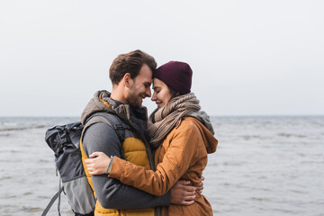 side view of couple embracing with closed eyes near sea