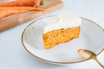Carrot cake with cream cheese on top on a bright white backround
