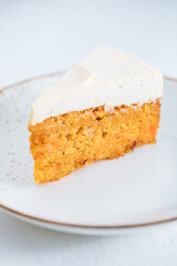 Carrot cake with cream cheese on top on a bright white backround