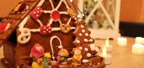 a self-made gingerbread house in front of Christmas decorations