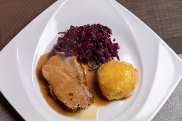 Roast pork with potato dumplings and red cabbage. Home made food.