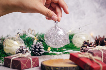 Hand holds a christmas sphere with gifts background