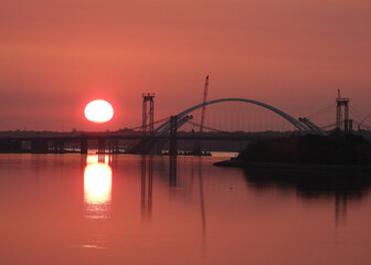 Fototapeta na wymiar Sun raising at the bridge construction site in Moline