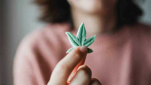 Cbd candy - Woman holding edible cannabis leaf for anxiety treatment - Marijuana alternative medicine