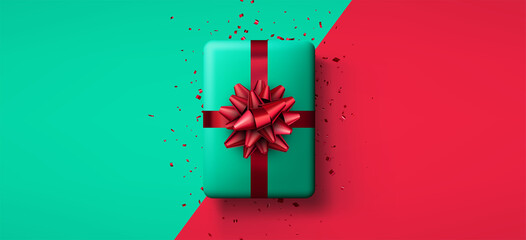 Green gift box with red bow and confetti.