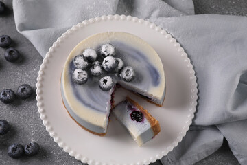 Blueberry cheesecake on a white plate on a gray table