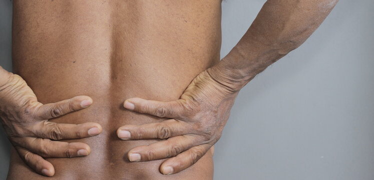 back pain discomfort after pulling a muscle with grey background stock photo
