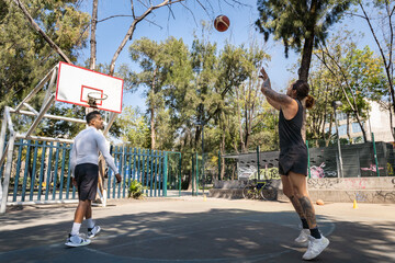 Práctica de baloncesto entre dos jugadores latinos en cancha de la Ciudad de México - tiro libre