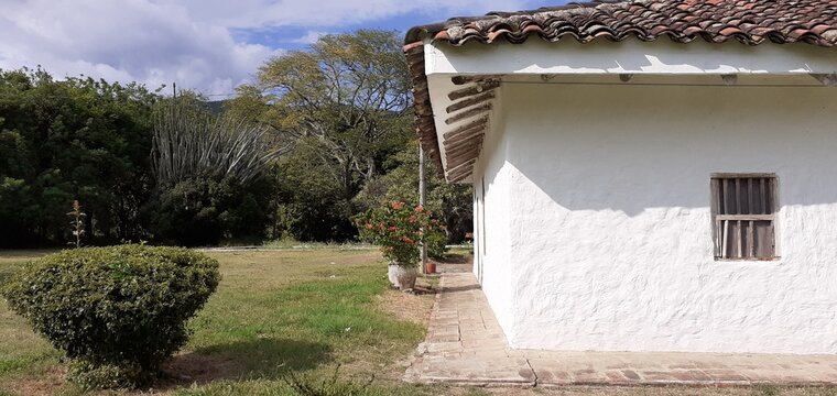 Antigua casona colonial blanca contrastando con el paisaje.