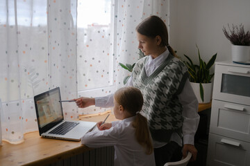 Two girls, sisters study at home, distance learning