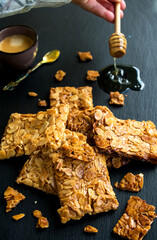 gebäck mit mandelplättchen, honig und einer tasse espresso