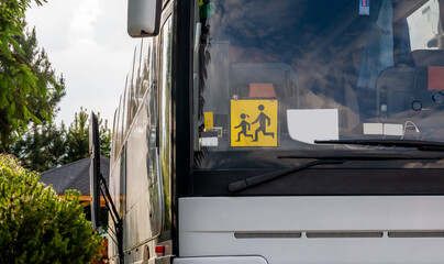 Single empty modern school trip bus, kids transport designated coach vehicle detail, closeup, nobody, frontal shot. Children journey safety concept. Traffic, transportation, means of transport © Tomasz